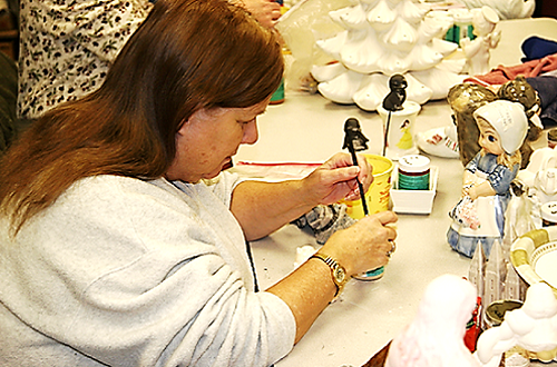 a UCB member is painting a ceramic figure
